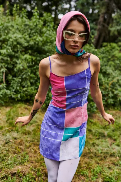 鮮やかなドレスと自然の中で夏の風を楽しむスタイリッシュなサングラスの美しい若い女性 — ストック写真