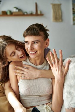 Sevecen iki kadın kanepede kucaklaşır..