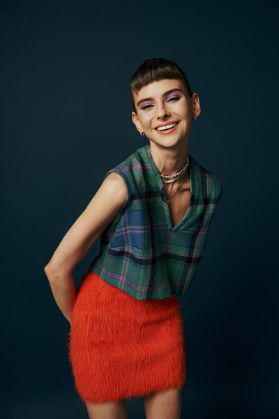 A graceful woman in a bright red skirt strikes a pose for a picture.