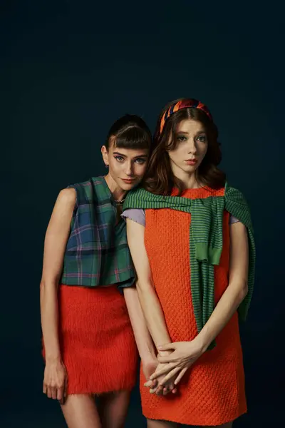 Two women in scarves standing close together.