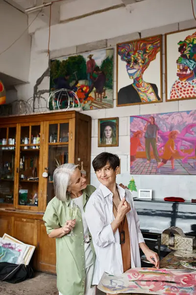 stock image Mature lesbian couple bonding in artistic space.