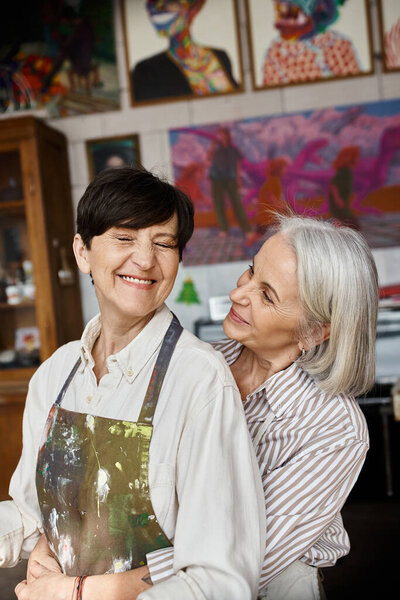 Two women collaborating in art studio.