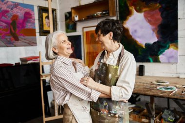 Two women creating art in a studio. clipart