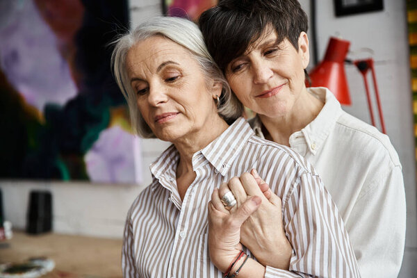 Две женщины обнимаются в уютной комнате.