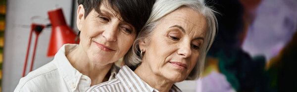 Две женщины обсуждают картину в художественной студии.