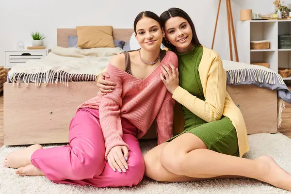 ファッショナブルなショットのために一緒にポーズする床に座っているカジュアルな服装の2つのスタイリッシュな若い女性 — ストック写真