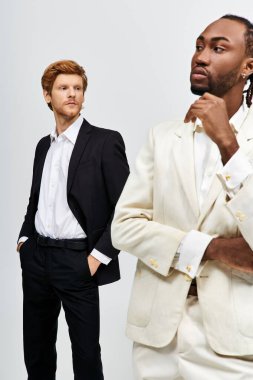 Two multicultural men in stylish suits standing side-by-side. clipart