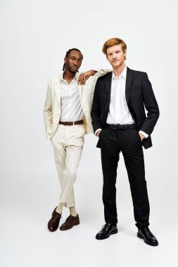 Two handsome multicultural men in stylish suits standing together. clipart
