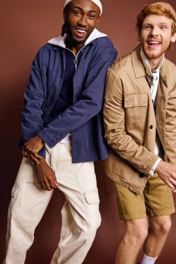 Farklı etnik kökenlere sahip iki modaya uygun genç adam yan yana duruyor..