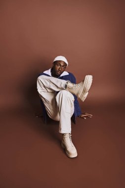 Şık giyinmiş bacak bacak üstüne atmış yakışıklı bir genç..