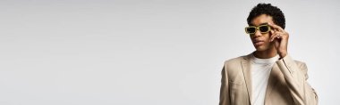 Bronz ceketli yakışıklı Afro-Amerikan adam şık güneş gözlüğü takıyor..