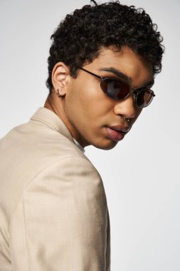 Bronz takım elbiseli ve güneş gözlüklü yakışıklı Afro-Amerikan adam..