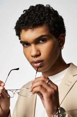 Genç adam şık güneş gözlüğü tutuyor..