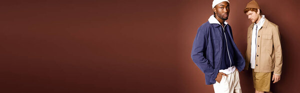 Two stylish multicultural men strike a pose together.