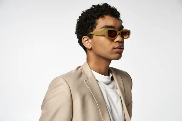 stock image Young man exudes style in tan suit and sunglasses.