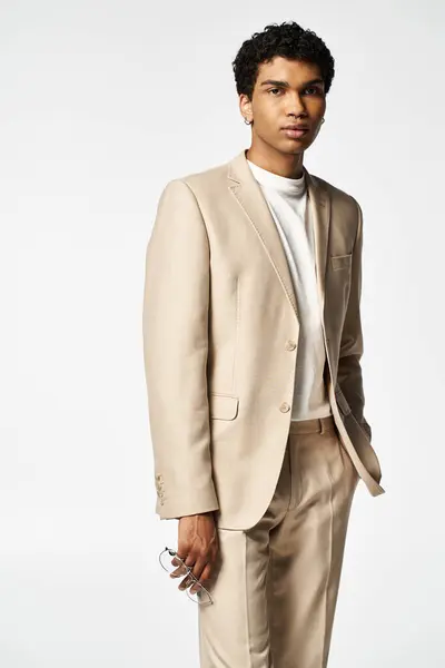 stock image Stylish African American man in tan suit strikes a pose for the camera with sunglasses on.