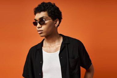 Siyah gömlekli yakışıklı genç adam şık güneş gözlüğü takıyor..