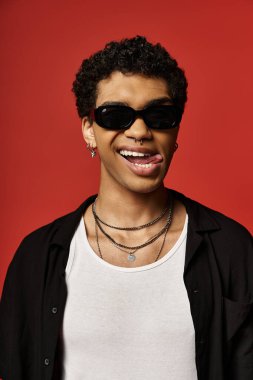 Güneş gözlüklü ve siyah gömlekli yakışıklı Afro-Amerikan bir adam..