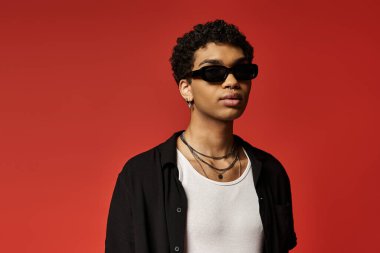 Yakışıklı Afro-Amerikan adam şık güneş gözlüğü ve beyaz gömlek giyiyor..