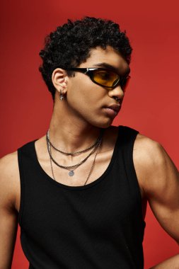 Güneş gözlüğü ve siyah atlet giyen yakışıklı Afro-Amerikan bir adam..