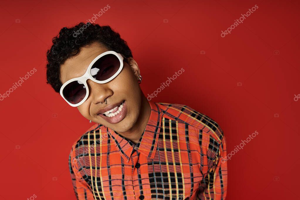 Handsome African American male in sunglasses and plaid shirt.