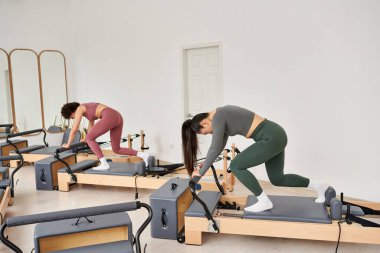 Women gracefully practicing in a gym setting. clipart