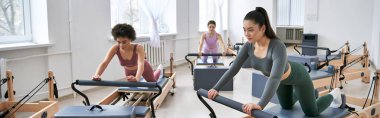 Çeşitli kadın grupları spor salonunda çeşitli egzersizler yapıyorlar..
