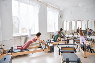 Spor salonundaki çeşitli kadın grupları sıkı bir egzersiz yapıyor..