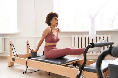 Pembe spor sutyenli ve taytlı genç Afrikalı kadın spor yapıyor..