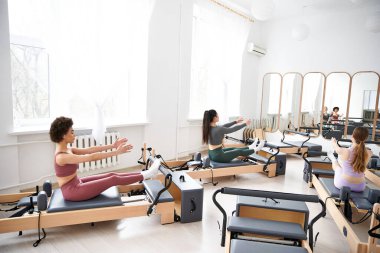 Bir grup ortamında pilates yapan kadınlar.