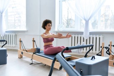 Pembe bluzlu bir kadın, egzersiz yapıyor..