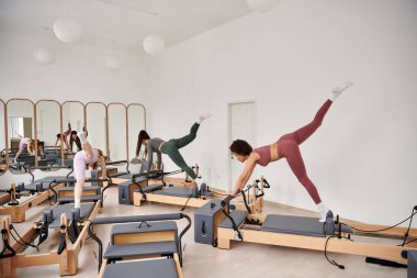 Sportif kadınlar spor salonunda pilates dersi sırasında egzersiz yapıyorlar..