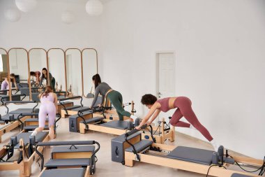 Spor salonunda pilates yapan bir grup sportif kadın..