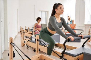 Spor salonunda pilates antrenmanı yapan çekici bir kadın grubu..