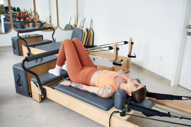 Güzel, sportif bir kadın spor salonunda pilates yapıyor..