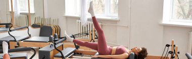 Güzel, sportif bir kadın, pilates dersi sırasında spor salonunda egzersiz yapıyor..