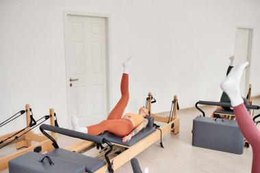 Sportif bir kadın arkadaşının yanında zarif bir şekilde egzersiz yapıyor..