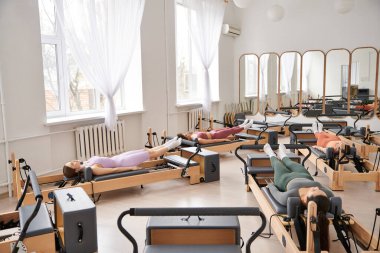 Spor salonunda pilates yaparken spor yapan bir grup güzel kadın..