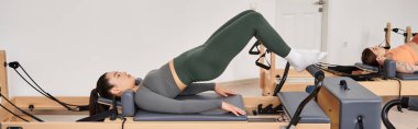Pilates seansı sırasında egzersiz yapan sağlıklı bir kadın..