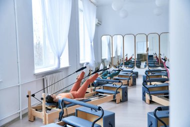 Atletik kadınlar pilates dersinde egzersiz yapıyorlar..