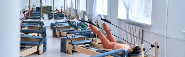 Pilates dersi sırasında spor yapan sporcu kadınlar..