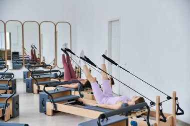 Pilates dersinde egzersiz yapan formda kadınlar..