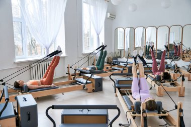 Genç kadınlar pilates dersinde egzersiz yapıyorlar..