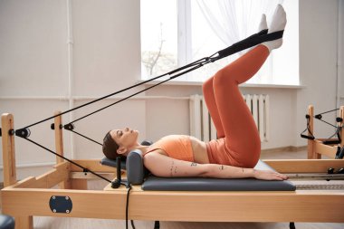 Pilates dersi sırasında sportif bir kadın..