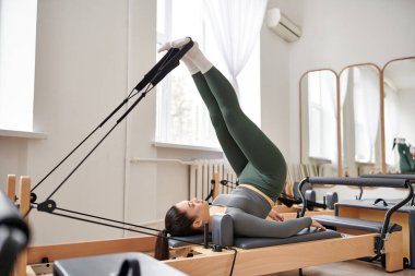 Sportif kadın pilates dersi sırasında egzersiz yapıyor..