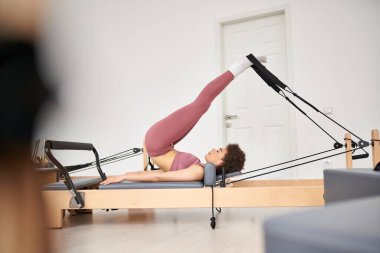 Baştan çıkarıcı kadın, pilates dersi sırasında incelikle egzersiz yapar..