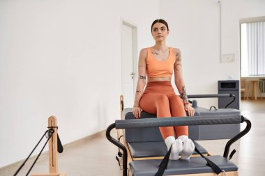 Odaklanma ve kararlılıkla pilates yapan sportif bir kadın..