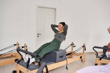 Alımlı kadın pilates yapıyor. Odaklanma ve kararlılıkla..