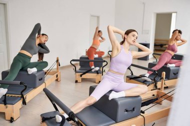Pilates dersine katılan enerjik kadınlar.