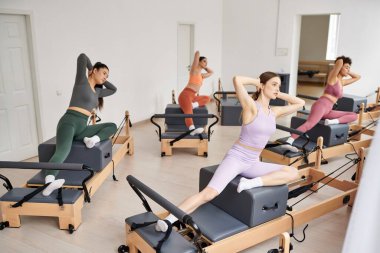 Spor salonunda pilates dersi sırasında spor yapan kadınlar..